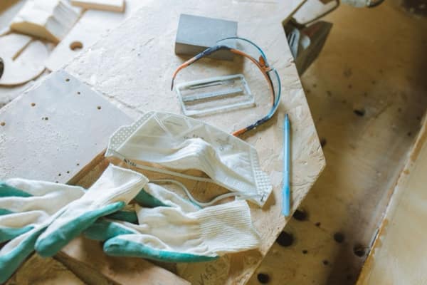 Work gloves, a dust mask and safety glasses on a workbench